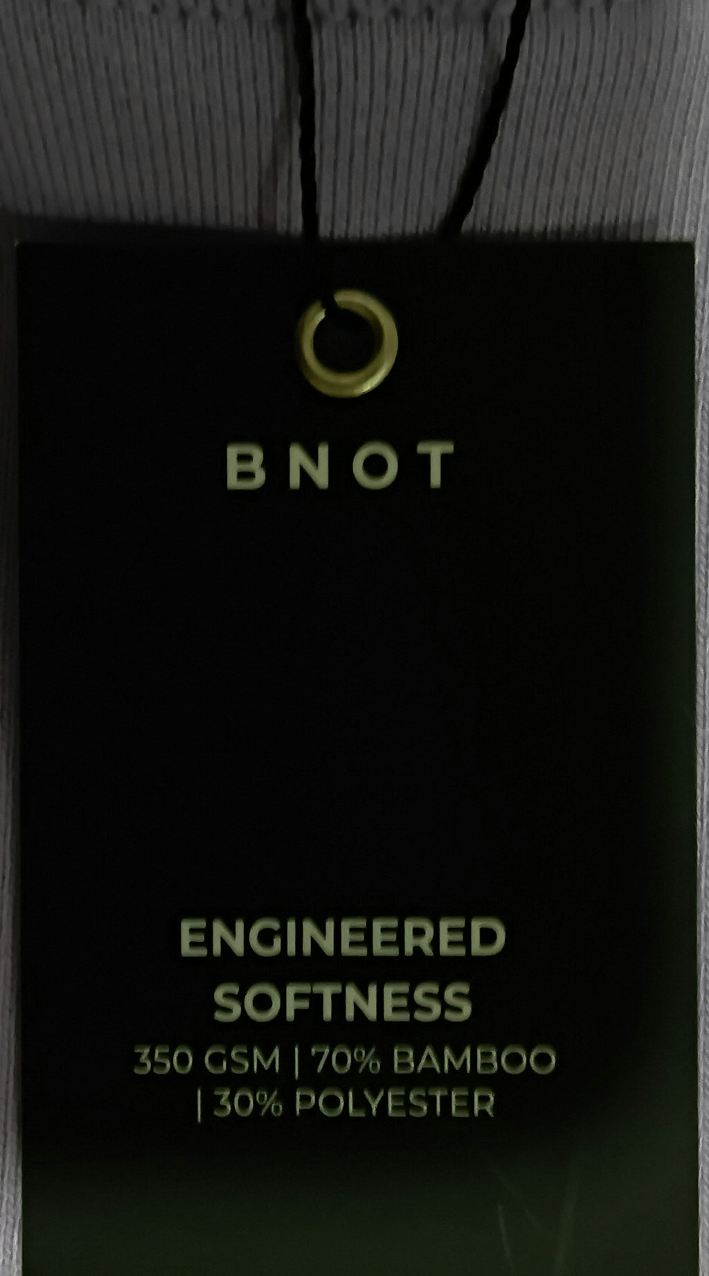 Close-up of BNOT black hoodie drawstring and metal eyelet hardware