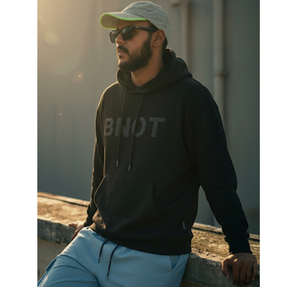 Model wearing black minimalist hoodie made of bamboo blend. 